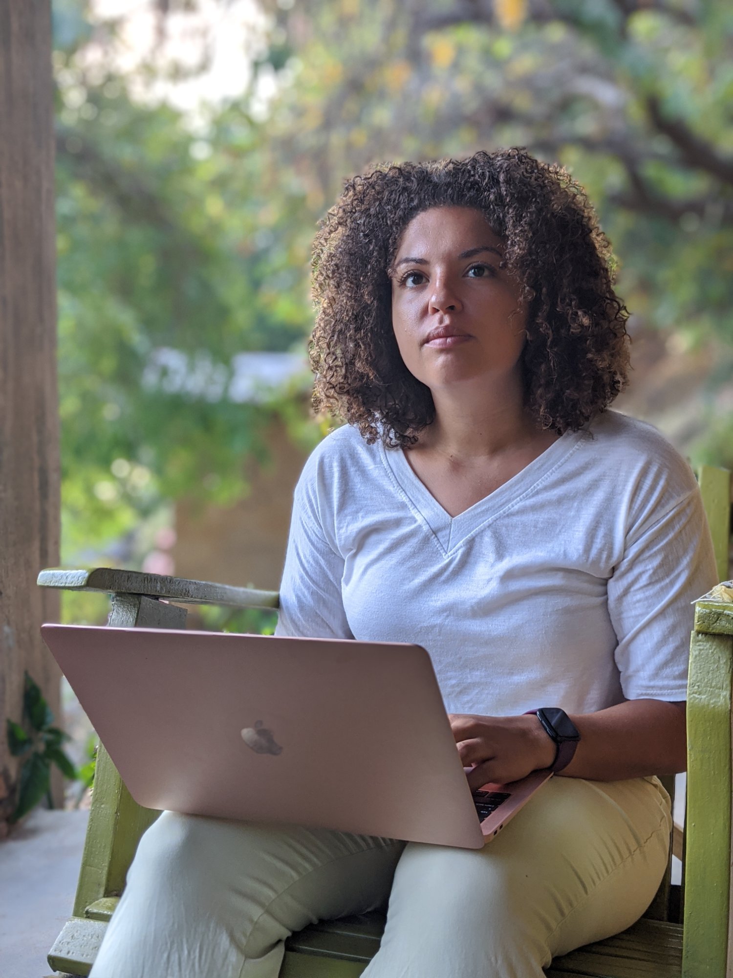 Amari Alexander working on a laptop from a porch in Malawi