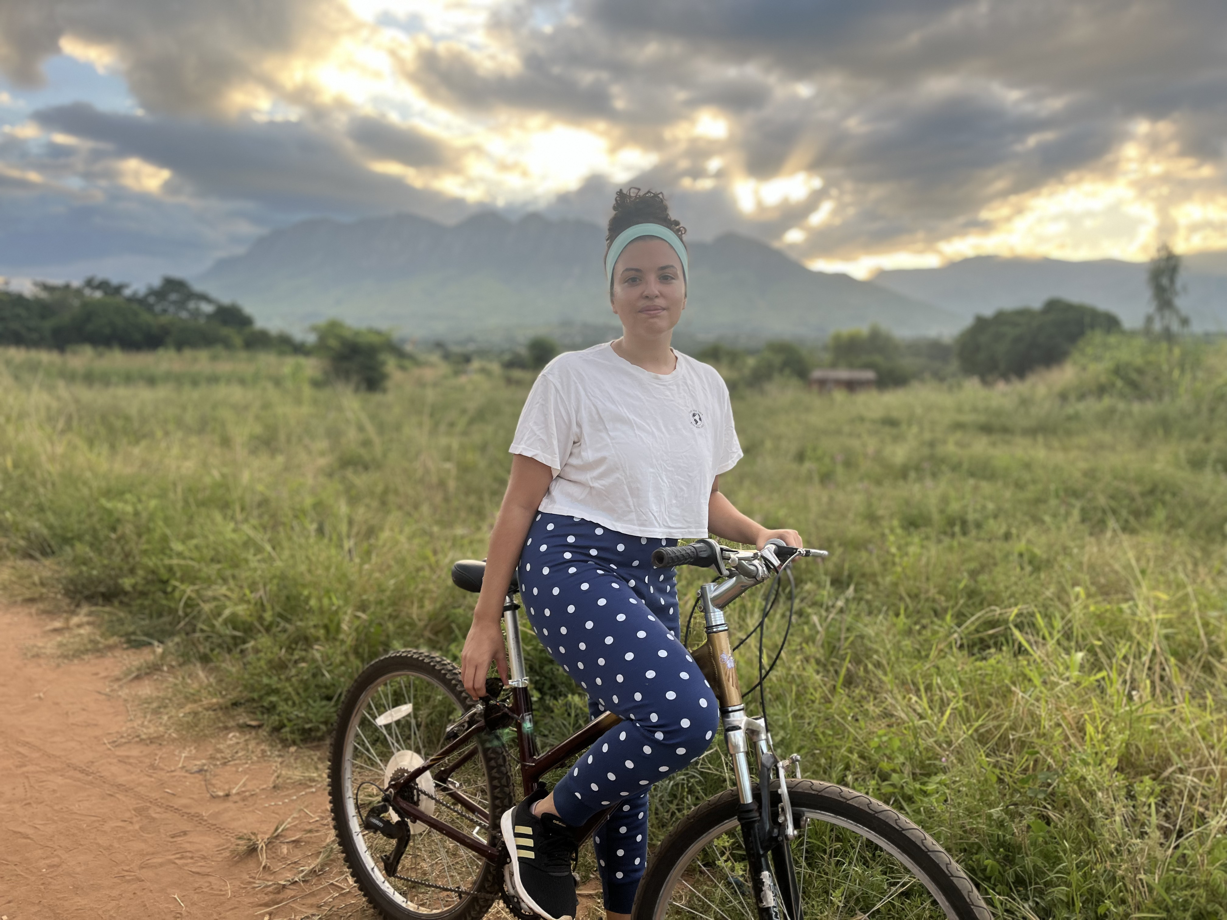 Amari on a bike in Zomba, Malawi with Zomba Plateau in the background